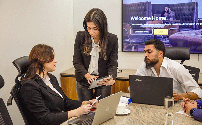 Boardroom at Qubic Square with people meeting and presenting using high-tech, fully equipped facilities.