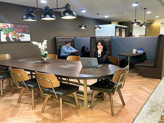 A modern coworking space at Servcorp Emirates Towers, Dubai, where clients are seen working in a professional yet relaxed environment.