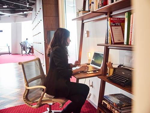  professional working at a stylish desk within a creative, open-plan environment—ideal for a virtual office setup at Servcorp, offering flexibility and a prestigious business presence.