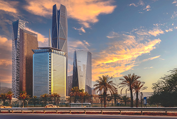 The skyline of King Abdullah Financial District (KAFD) glows at sunset, highlighting its striking architectural towers and palm-lined surroundings—symbolizing Riyadh’s thriving business future.